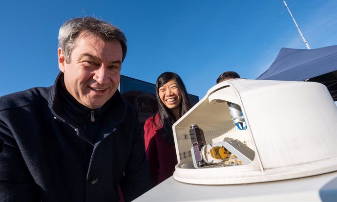11 October 2021, Bavaria, Munich: Markus Soeder (L), Minister-President of Bavaria, and Jia Chen, Professor of Environmental Sensors and Modeling at the Technical University of Munich (TUM), stand on top of a building in the city centre behind a measuri