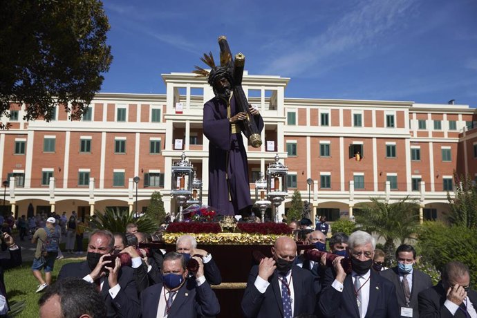 Hermanos con cirios, portando mascarillas, durante la Santa Misión 2021 a 16 de octubre de 2021 en la Plaza de San Lorenzo de Sevilla (Andalucía, España)