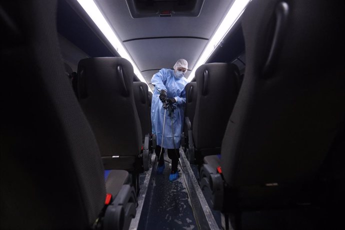 Archivo - 16 March 2020, Russia, Saint-Petersburg: A worker in protective suit disinfects a bus as a precaution against the spread of Coronavirus (Covid-19)in Saint-Petersburg. Photo: Sergei Mikhailichenko/SOPA Images via ZUMA Wire/dpa