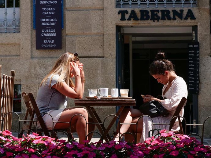 Archivo - Dos mujeres en la terraza de un restaurante de la Rua da Raiña, en Santiago de Compostela