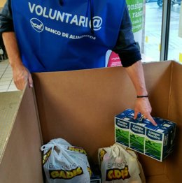Archivo - Una persona voluntaria del Banco de Alimentos de Vigo recoge alimentos donados.