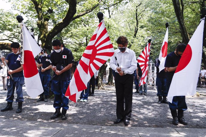 Archivo - 15 August 2020, Japan, Tokyo: People wearing face masks hold the Imperial Rising Sun flags during their visit to the Yasukuni Shrine to pay tribute to the war dead on the occasion of the 75th anniversary of Japan's surrender in WWII. Photo: Ro
