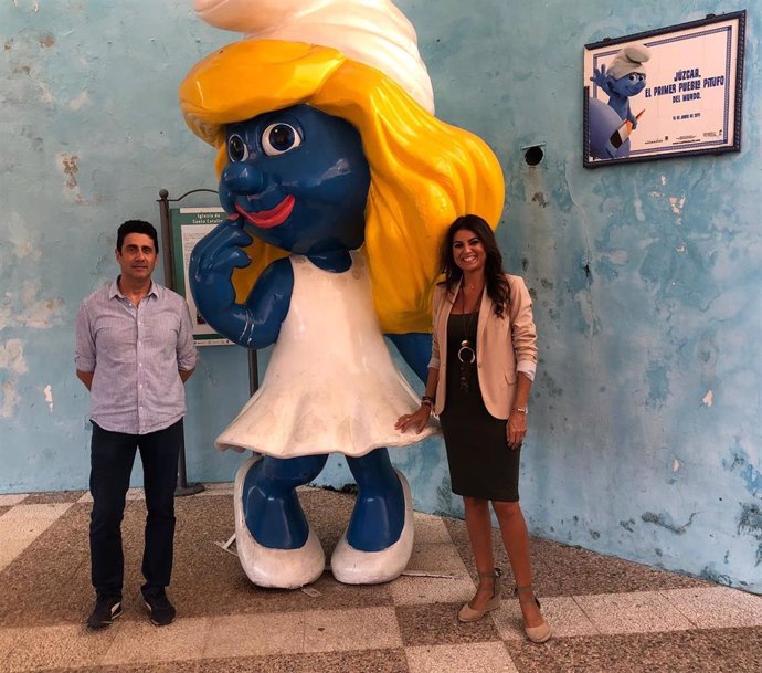 La delegada de Turismo, Nuria Rodríguez, y el alcalde de Júzcar, junto a una imagen de pitufina