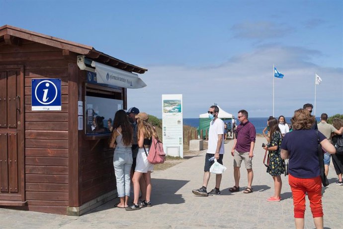 Archivo - Turistas hacen cola ante una oficina de información turística, frente a la playa de Las Catedrales.