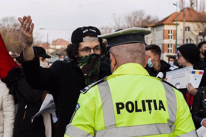 Archivo - Un hombre se enfrenta a un agente de la Policía en Timisoara, Rumanía, en una manifestación contra las medidas impuestas para frenar la pandemia de COVID-19. 