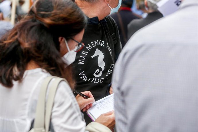 Un hombre con una camiseta que reclama un Mar Menor "vivo", participa en una recogida de firmas en una manifestación