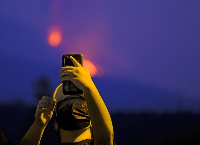 Un hombre fotografía con su teléfono móvil una de las bocas eruptivas del volcán de Cumbre Vieja