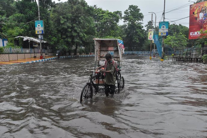 20 September 2021, India, Kolkata: A rickshaw puller tries to make his way through a flooded road in Kolkata after a heavy rains. Photo: Debarchan Chatterjee/ZUMA Press Wire/dpa