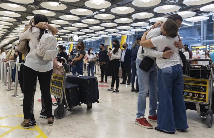 Dos parejas se abrazan en la Terminal T4 del Aeropuerto Adolfo Suárez Madrid - Barajas, a 15 de octubre de 2021, en Madrid (España). El Gobierno suprime desde este viernes los límites y restricciones impuestas con motivo de la pandemia de coronavirus en