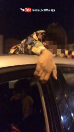 Menor sobre el techo de un coche que  circuló por calles de Málaga