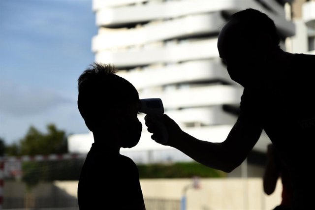 Archivo - Una profesora toma la temperatura a un niño en un colegio de València.  