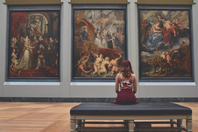 Una mujer observando una obra de arte en un museo.