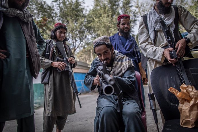 22 September 2021, Afghanistan, Kabul: A young Taliban fighter fools around with his rifle as he guards outside a police station in Kabul. Photo: Oliver Weiken/dpa