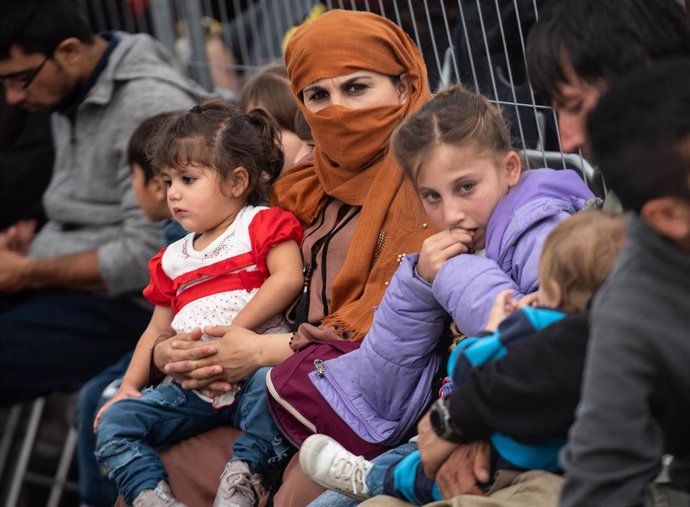 Una mujer afgana espera con su familia para salir desde Alemania hacia una base estadounidense.