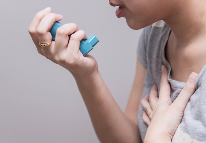 Archivo - Asian woman using a pressurized cartridge inhaler extended pharynx, Bronchodilator