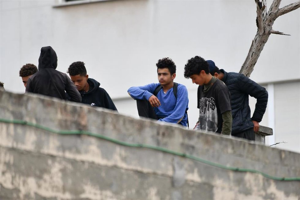 Archivo - Varios menores migrantes, en el tejado de una nave industrial, a 27 de agosto de 2021, en Ceuta.