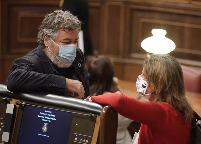 El diputado de Unidas Podemos, Juan Antonio López de Uralde, conversa con la vicepresidenta tercera y ministra para la Transición Ecológica y el Reto Demográfico, Teresa Ribera