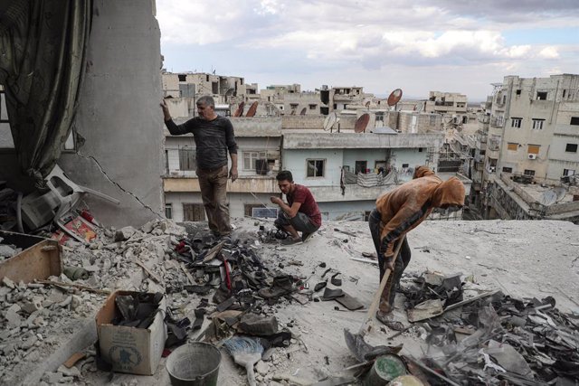 20 October 2021, Syria, Ariha: Khaled Ibrahim, 58, and his children clean the rubble from their house in Ariha, which was destroyed after it was hit earlier in the day in a missile shelling, allegedly carried out by Syrian government forces. Several peopl