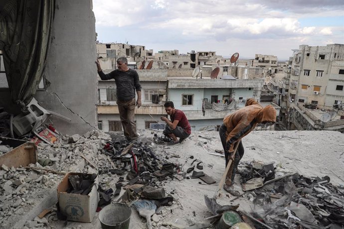 20 October 2021, Syria, Ariha: Khaled Ibrahim, 58, and his children clean the rubble from their house in Ariha, which was destroyed after it was hit earlier in the day in a missile shelling, allegedly carried out by Syrian government forces. Several peo