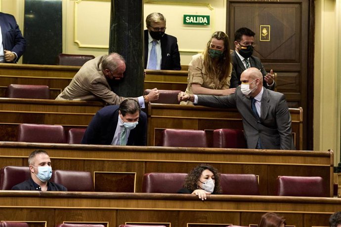 Archivo - El diputado de Vox, Víctor Manuel Sánchez Del Real (d), choca la mano con miembros del partido tras una intervención en el Congreso
