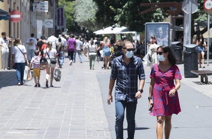 Archivo - Un hombre con mascarilla en el centro de una ciudad.