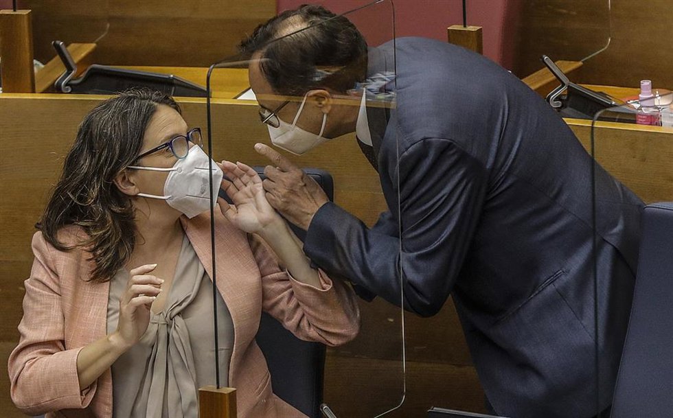 La vicepresidenta de la Comunitat Valenciana, Mónica Oltra, y el conseller de Hacienda, Vicent Soler, conversan durante un pleno de Les Corts