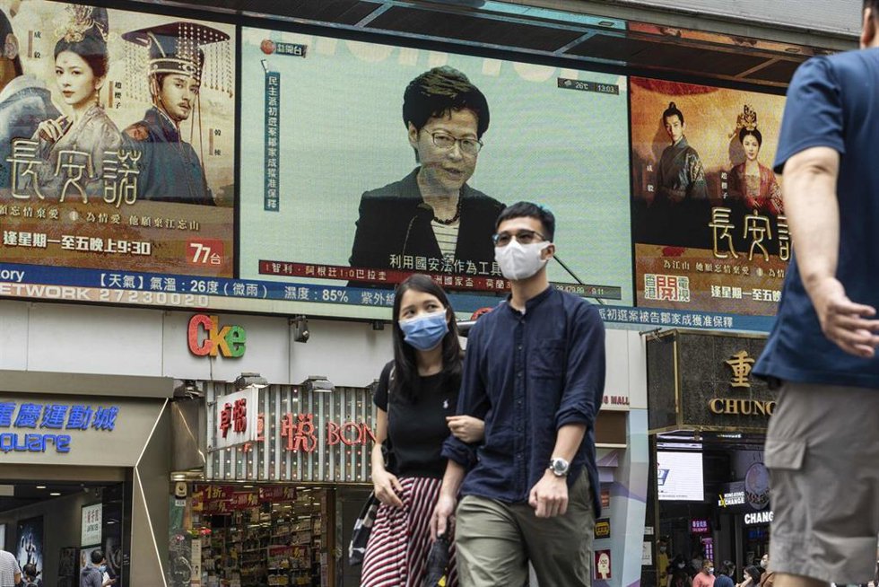 Archivo - Ciudadanos de Hong Kong pasean delante de una comparecencia de la jefa ejecutiva del territorio, Carrie Lam 