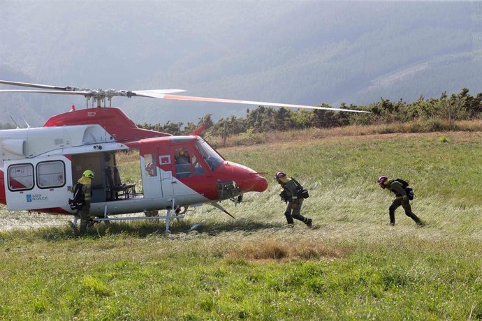 Archivo - Dos bomberos se suben a un helicóptero en un incendio forestal en la parroquia de Cubilledo, en el municipio de Baleira, comarca de A Fonsagrada, a 18 de agosto de 2021, en Lugo, Galicia (España). Según la Conselleria de Medio Rural, el incend