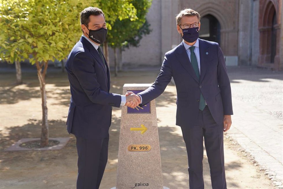 Juanma Moreno (i.) y Alberto Núñez Feijóo, este viernes en la inauguración del Monolito indicativo del Camino de Santiago, ubicado en el Patio de los Naranjos del Monasterio de San Isidoro del Campo de Santiponce (Sevilla)