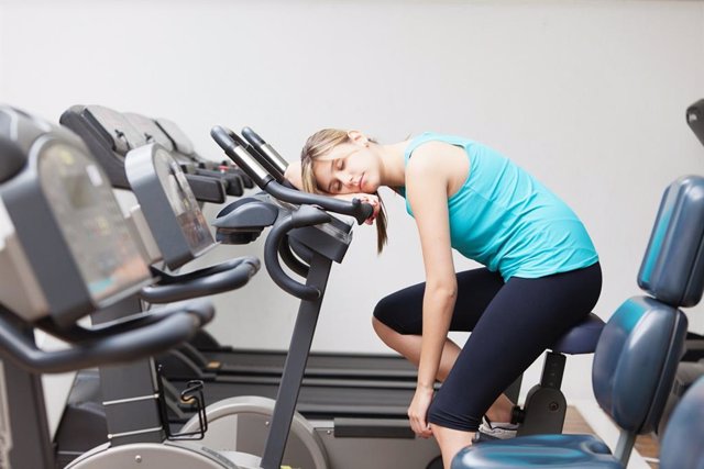 Mujer demasiado cansada para hacer ejercicio en el gimnasio.
