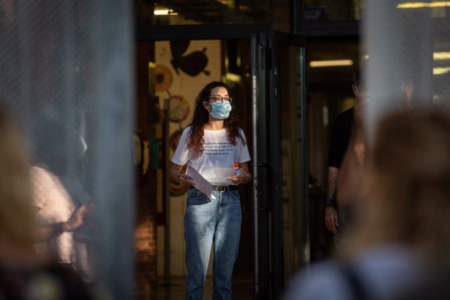 Archivo - Arxivo - Una professora amb mascarilla a les portes d'un collegi a Barcelona.