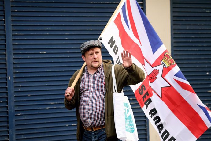 Archivo - 17 September 2021, United Kingdom, Belfast: An anti Northern Ireland Protocol protester holds a flag during a rally against the post-Brexit arrangements in Newtownards Road. Photo: Peter Morrison/PA Wire/dpa