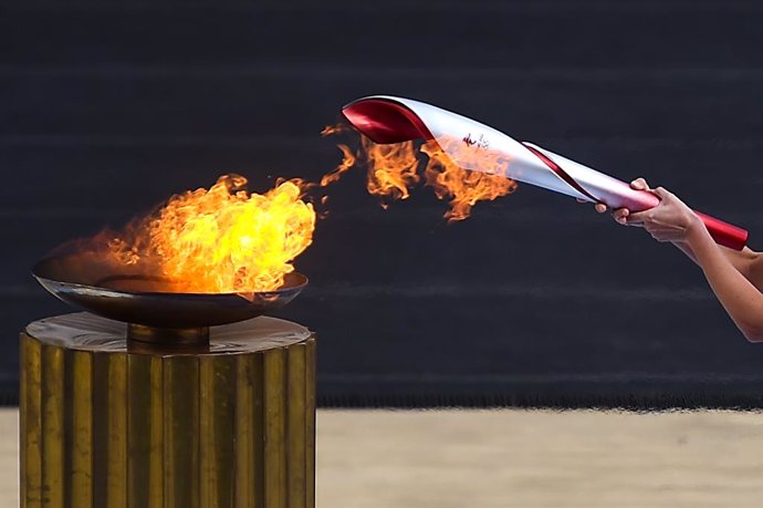 19 October 2021, Greece, Athens: Greek actress Xanthi Georgiou, playing the role of the High Priestess, lights the Winter Olympic torch with a flame during the flame handover ceremony for the Beijing 2022 Winter Olympic Games at the Panathenaic Stadium.