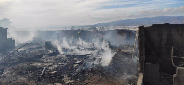 Bomberos actúan en el incendio del poblado chabolista de Atochares en Níjar (Almería).