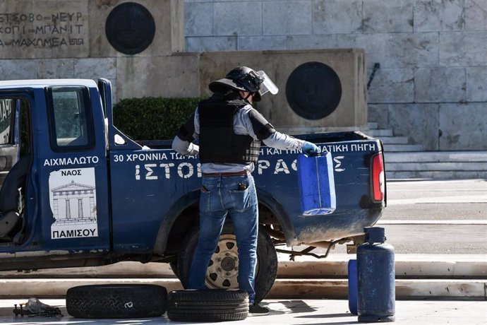 Un agente antibombas comprueba una camioneta frente al Parlamento griego.