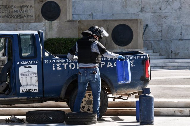 04 October 2021, Greece, Athens: Bomb disposal officer check a pick up truck in front of the Greek Parliament. Police in Greece have halted traffic outside parliament in central Athens after a man drove a pickup truck onto a sidewalk in front of the build
