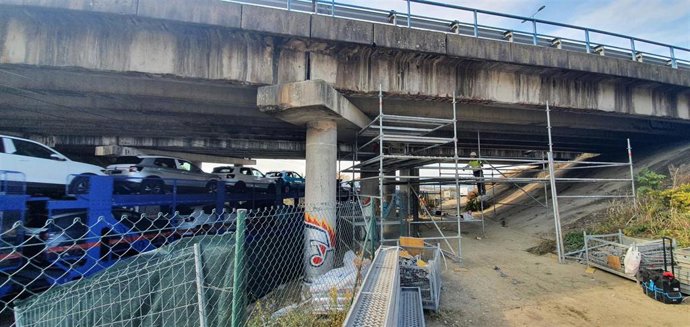 Un tren de mercancías cruza bajo el puente de la PA-34 a su paso por Berriozar, donde se han iniciado los trabajos de adecuación de la estructura.