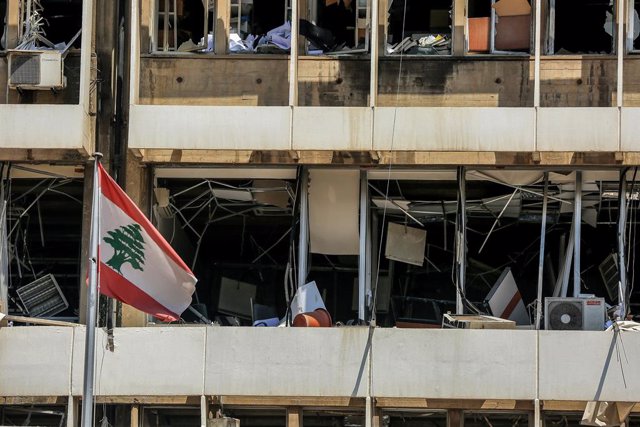 Archivo - Una bandera de Líbano frente a un edificio dañado por las explosiones en el puerto de Beirut