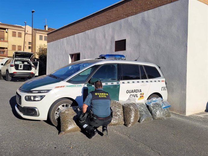 Agente de la Guardia Civil junto a la marihuana interceptada.