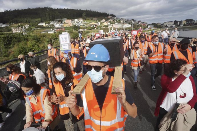 Dos hombres portan sobre sus hombros una simulación de un féretro, en una manifestación por el futuro industrial de A Mariña, a 17 de octubre de 2021, en Viveiro, Lugo (Galicia). Viveiro acoge este domingo una manifestación convocada por los sindicatos 