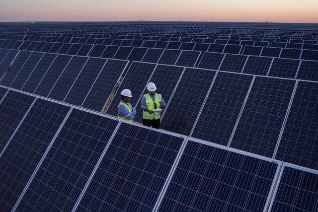 03 April 2021, Saudi Arabia, Sakaka: Two engineers stand amongst the solar panels at the solar farm of the Sakaka solar project, a 300MW photovoltaic solar farm developed on a 6-kilometer-square site near Sakaka. Photo: -/Saudi Press Agency/dpa