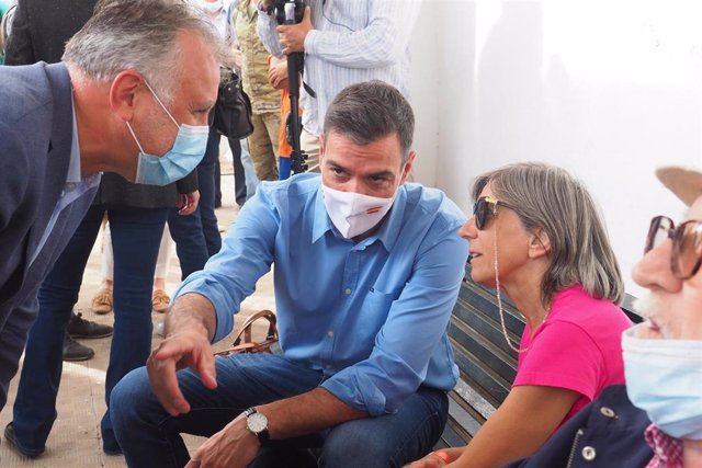 Archivo - El presidente de Canarias, Ángel Víctor Torres (i), y el presidente del Gobierno, Pedro Sánchez (d), conversan con una vecina durante su visita al Centro de acogida de afectados por la emergencia volcánica