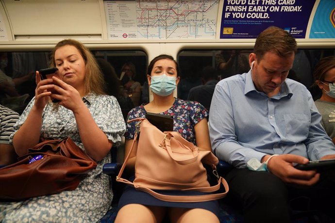 Archivo - 19 July 2021, United Kingdom, London: Commuters, some still wearing mouth-nose protection, sit in a Jubilee Line tube train to Westminster after the last Coronavirus measures were lifted. Despite dramatically rising infection figures, almost a