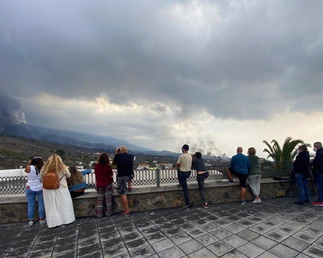 A group of people observe the eruption of the La Palma volcano from the Tajuya viewpoint