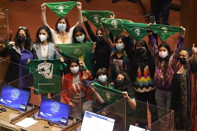 28 September 2021, Chile, Santiago: Women covering their mouths and noses hold up green scarves to celebrate the approval of abortion up to 14 weeks gestation (SSW) by the House of Representatives in Parliament. Photo: Leonardo Rubilar/Agencia Uno/dpa