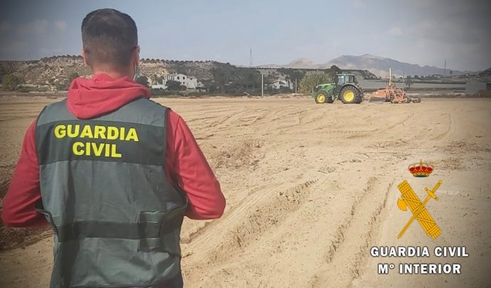 Un agente de la Guardia Civil frente a un tractor.