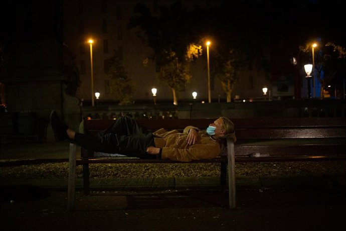 Archivo - Un hombre duerme sobre un banco.