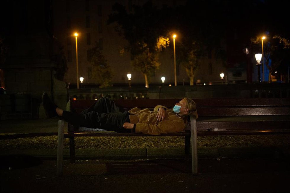 Archivo - Un hombre duerme sobre un banco.