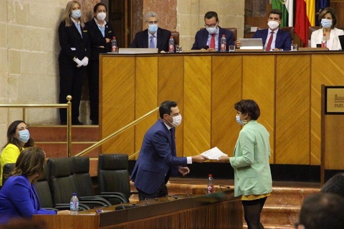 Imagen del momento en que la diputada no adscrita y portavoz de Adelante Andalucía, Teresa Rodríguez, entrega sus propuestas de resolución no debatidas al presidente de la Junta, Juanma Moreno.