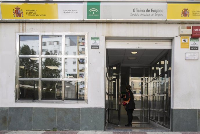 Archivo - Una mujer entra en una oficina de empleo en Sevilla, foto de recurso